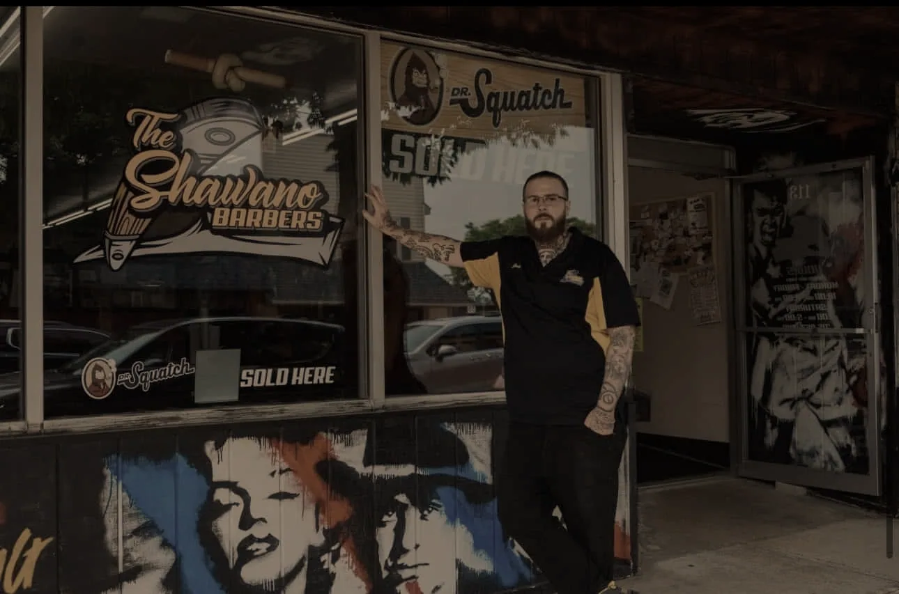 Jesse Krajenka outside The Shawano Barbers at 113 S Main Street — the shop's own photograph, published with the Business News piece.